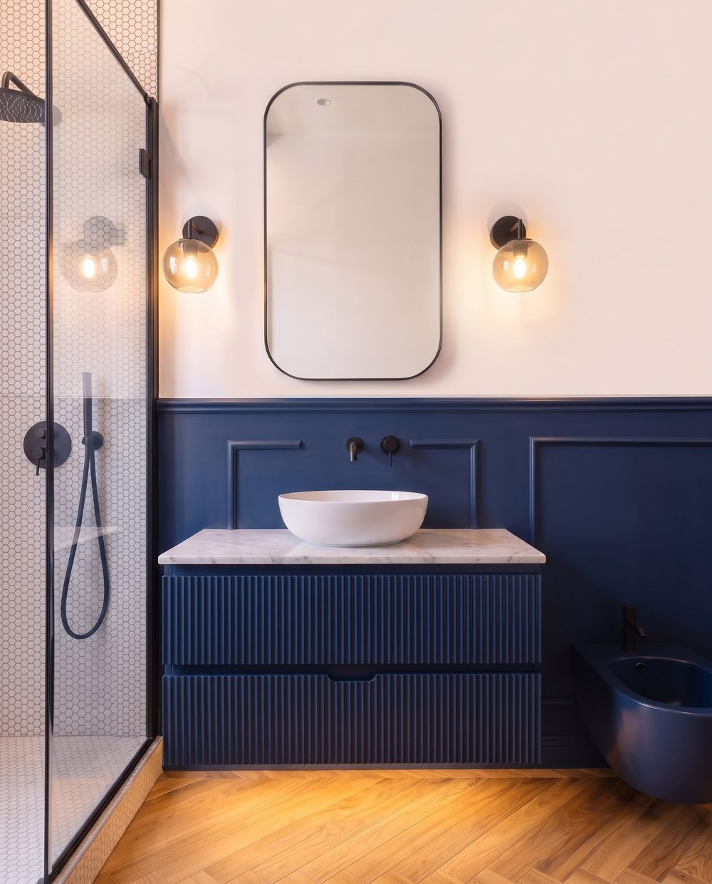 Mobile lavabo su misura inserito nella boiserie in legno a parete.