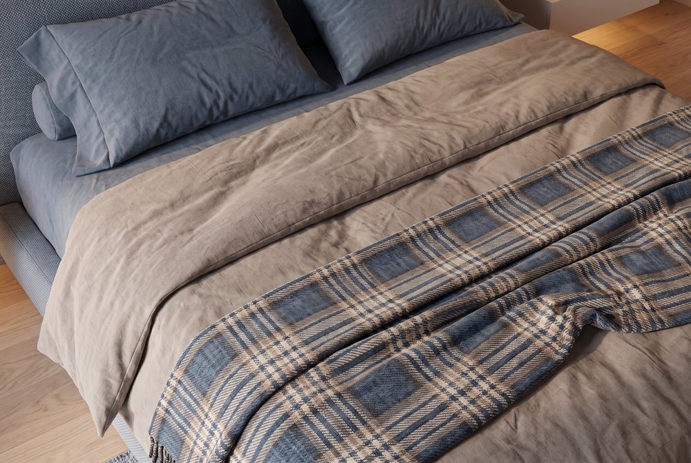 Dettaglio dei tessuti del letto, con testata imbottita e coperta in velluto.